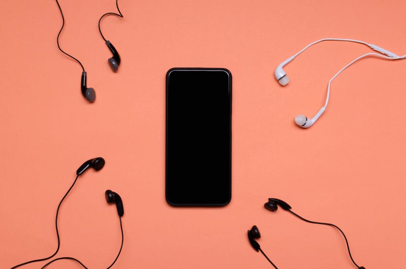 View of blank smartphone screen and many earphones.