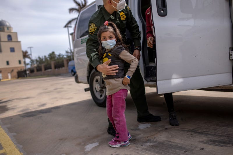 A U.S. Border Patrol agent delivers a young asylum seeker 