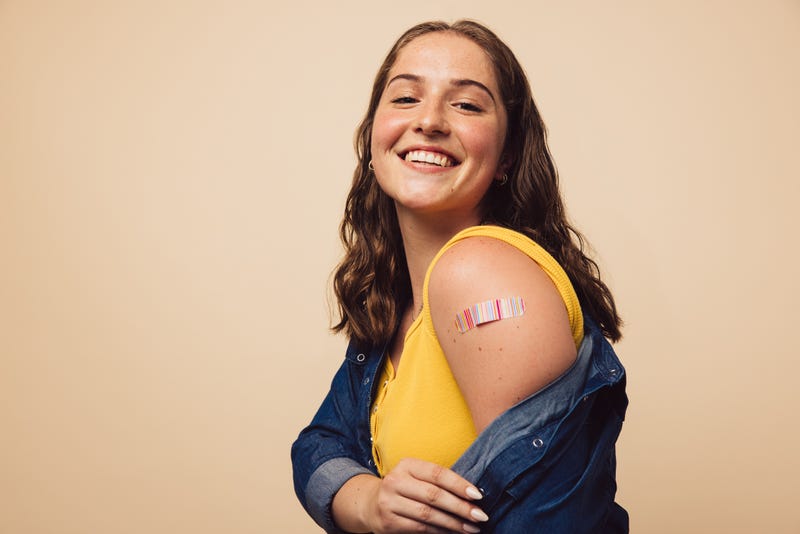 Woman with band-aid on arm stock photo.