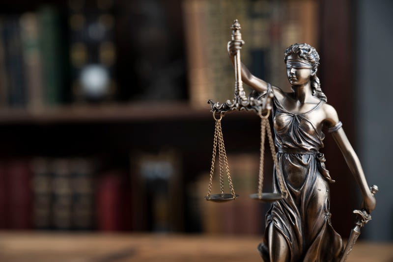 Themis statue on the shelf with legal books background.