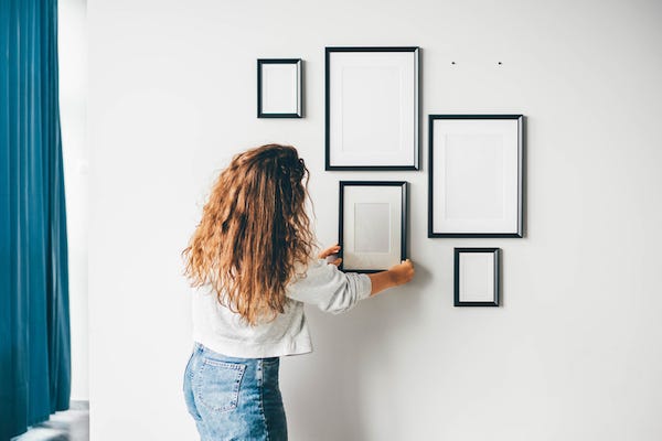 Woman hanging a frame on a wall