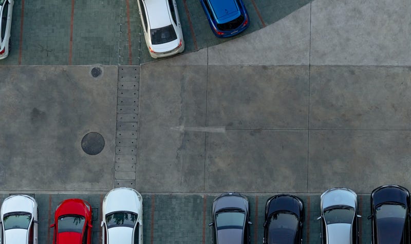 A car backs into a parking lot