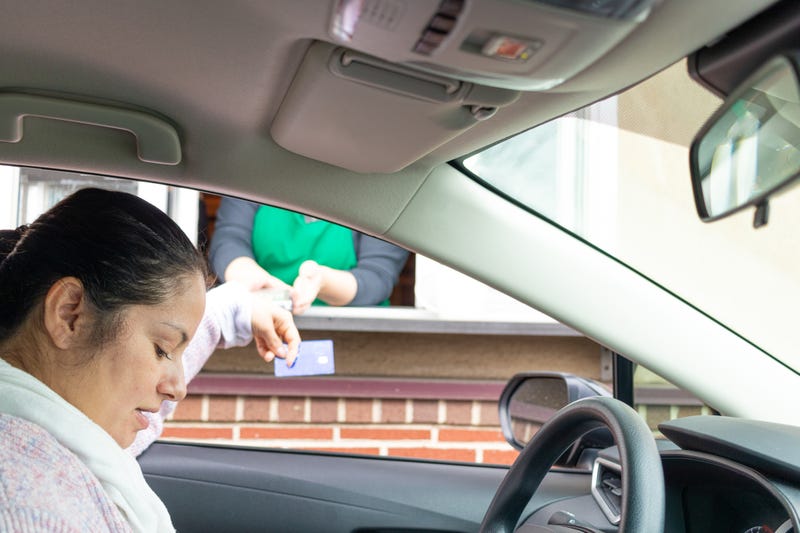 Young woman pays for service through Drive thru