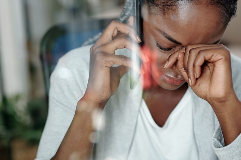 A woman grieving while talking on the phone.