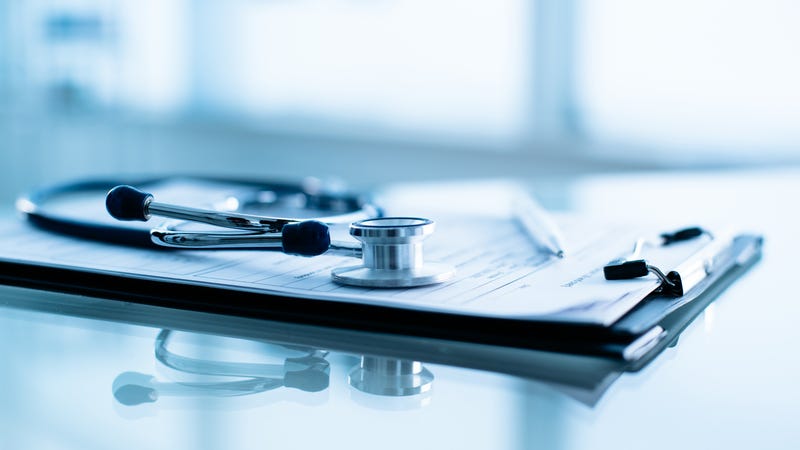 Health Care paperwork underneath stethoscope
