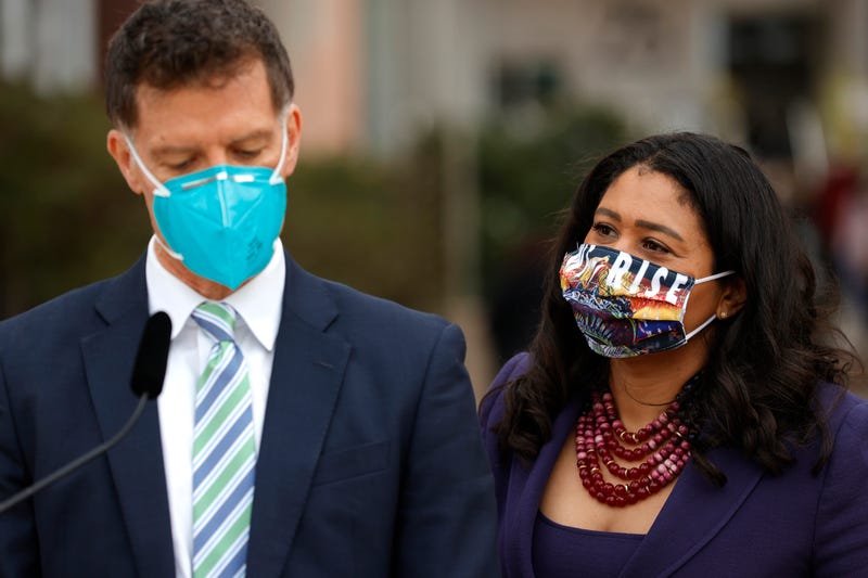 San Francisco Mayor London Breed (R) looks on as Dr. Grant Colfax, Director of Health for the City and County of San Francisco, speaks during a news conference outside of Zuckerberg San Francisco General Hospital with essential workers to mark the one year anniversary of the COVID-19 lockdown on March 17, 2021 in San Francisco, California.