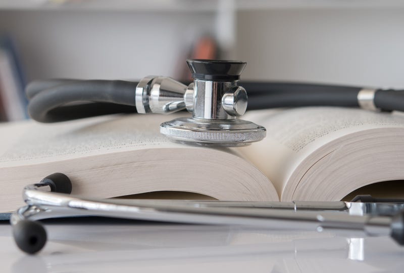 stethoscope on stack of medical guide book for doctor learning treatment at hospital