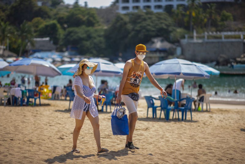 Tourists wearing a mask walk along Caleta beach on March 19, 2021 in Acapulco, Mexico. Acapulco began its vaccination plan for senior citizens on March 17, people over 60 years old will receive the first dose of the vaccine against Covid-19. Acapulco remains as one of the favourite tourist destination for Mexicans. 