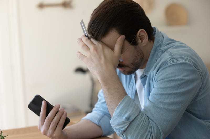 Man with credit card holding head stock image.