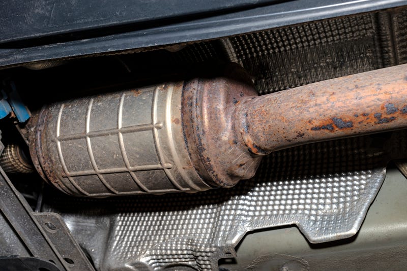 A diesel particulate filter in the exhaust system in a car on a lift in a car workshop
