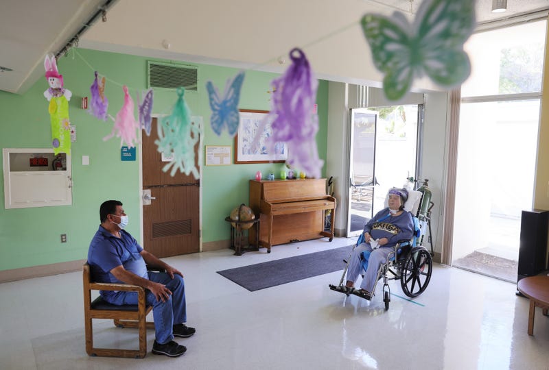 LOS ANGELES, CALIFORNIA - MARCH 22: Eliseo Vera (L) speaks with his mother Esther Ortega, while they are reunited with social distance, at Providence Holy Cross Medical Center’s Sub-Acute Center in the Mission Hills neighborhood on March 22, 2021 in Los Angeles, California.
