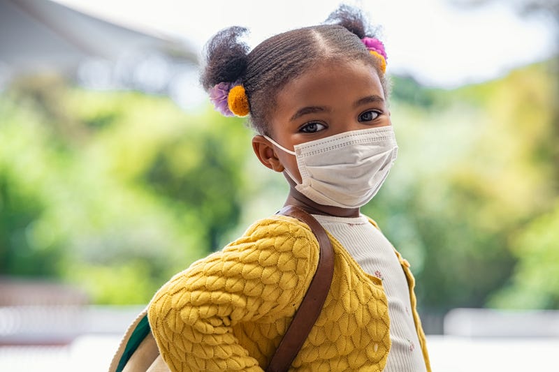 A young student wearing a mask to school.