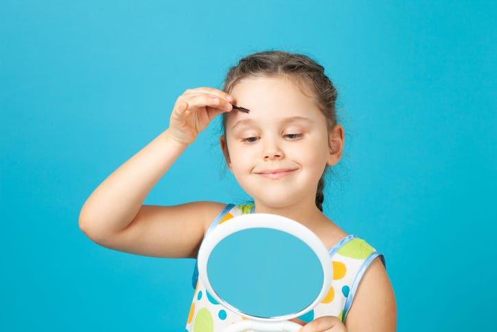 Young girl doing her makeup