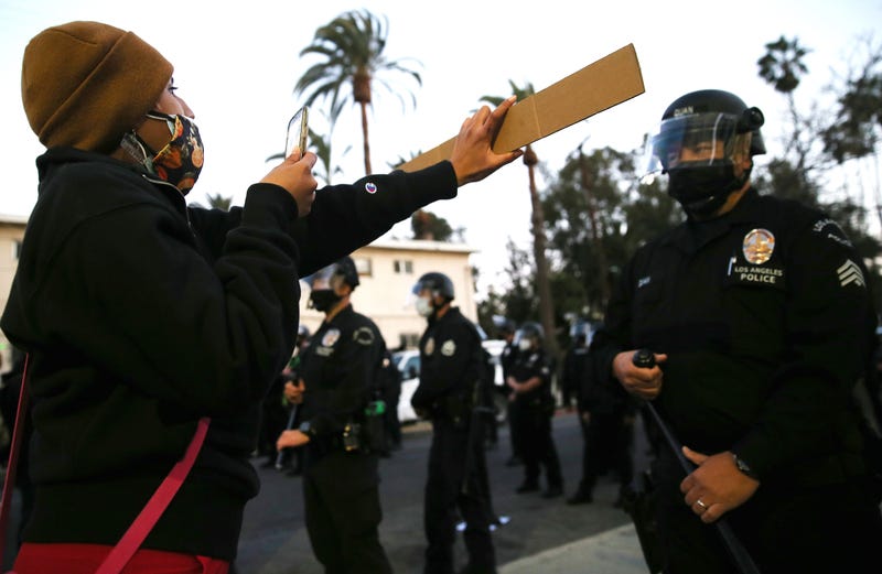Protesters demonstrate against the removal of a homeless encampment as LAPD officers block the street near Echo Park Lake on March 25, 2021 in Los Angeles, California.