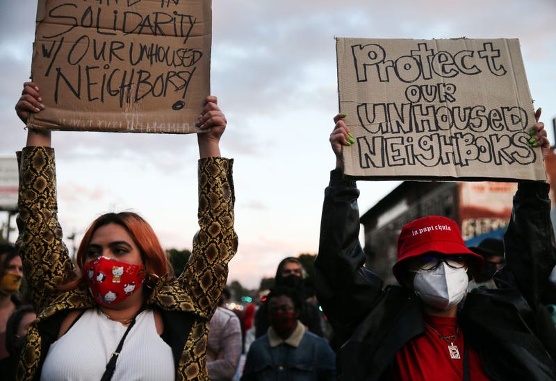 : Protesters demonstrate on Sunset Boulevard against the removal of a homeless encampment at Echo Park Lake on March 25, 2021 in Los Angeles, California. People who were living in tents during the pandemic at the park were asked to leave by officials recently. The park was fenced off yesterday evening and a cleanup of the area began today. (Photo by Mario Tama/Getty Images)