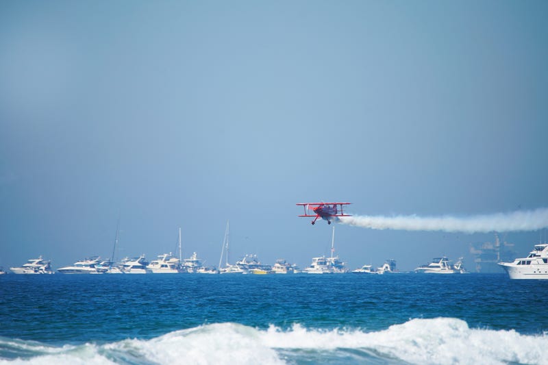 A Bi Plane streaks across the ocean at the Great Pacific Airshow in Huntington Beach, California.