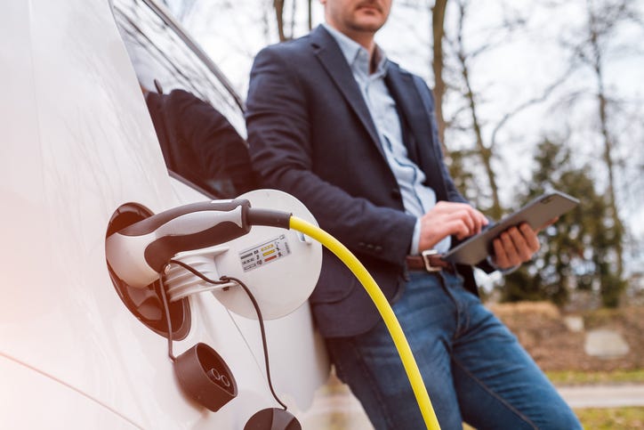 man charging an electric vehicle