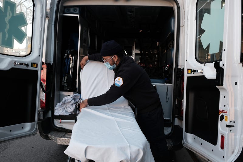 An EMT worker cleans a gurney after transporting a suspected Covid patient outside of a Brooklyn hospital on March, 29 2021 in New York City