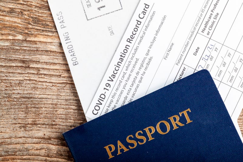 a passport, a boarding pass and a COVID-19 vaccination record card