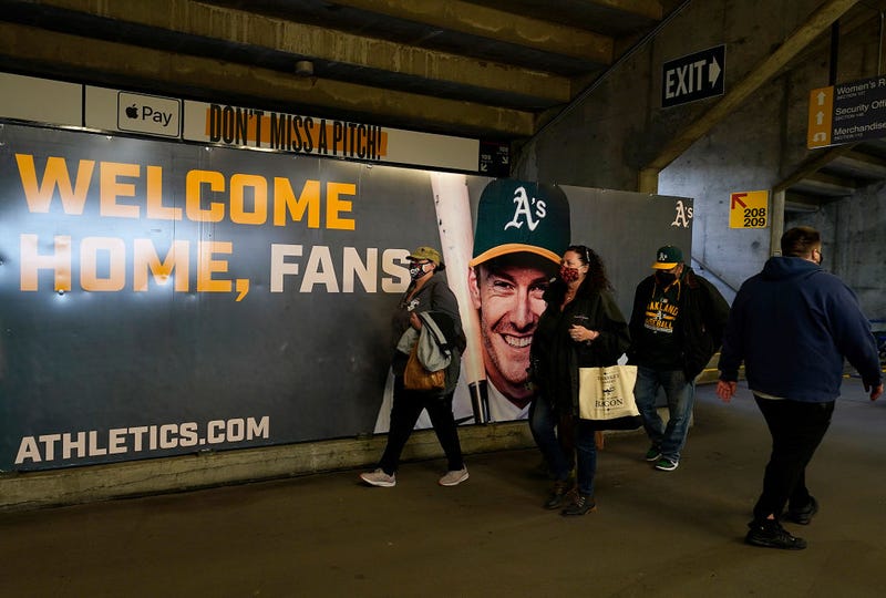 Fans walk past a sign posted that reads "Welcome Home Fans" with a photo of Mark Canha #20 of the Oakland Athletics prior to the game against the Houston Astros at RingCentral Coliseum on April 02, 2021 in Oakland, California.