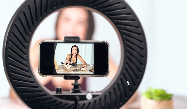 Female vlogger filming makeup tutorial