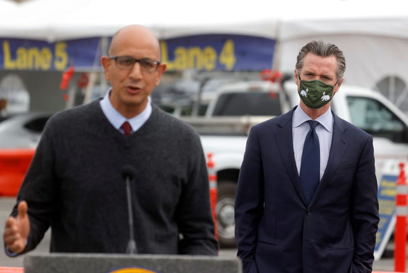 California Gov. Gavin Newsom (R) looks on as California Health Secretary Dr. Mark Ghaly speaks during a news conference after touring the vaccination clinic at City College of San Francisco on April 06, 2021 in San Francisco, California.