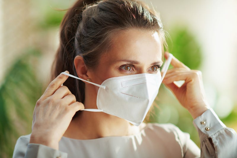 Woman putting on face mask