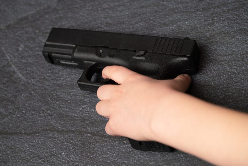 Child's hand on gun stock photo.