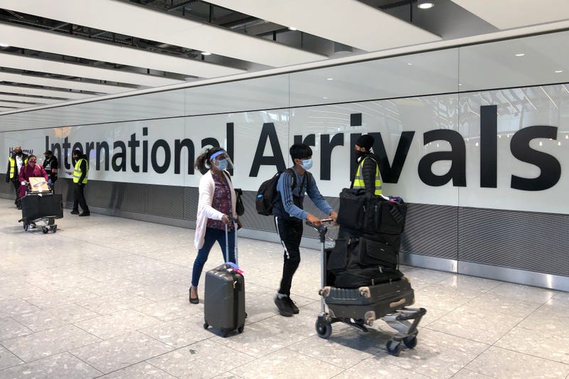 Passengers are escorted through the arrivals area of terminal 5 towards coaches destined for quarantine hotels, after landing at Heathrow airport in London, England