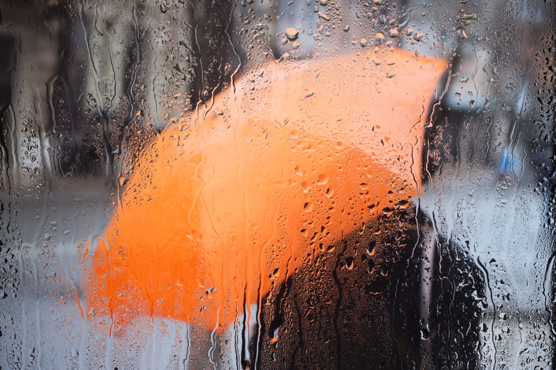 orange umbrella on the other side of a rainy window