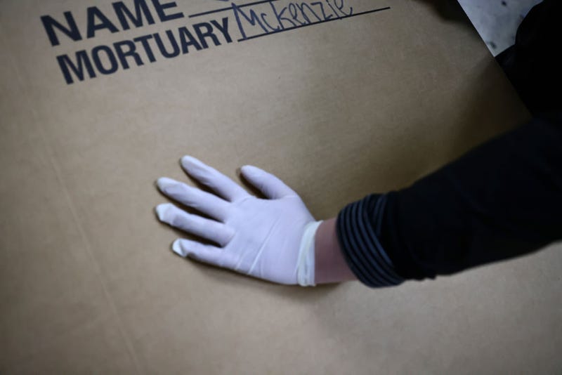 A worker prepares a person for cremation amid an overflow of the deceased during the COVID-19 pandemic at McKenzie Mortuary Services on March 29, 2021 in Long Beach, California.