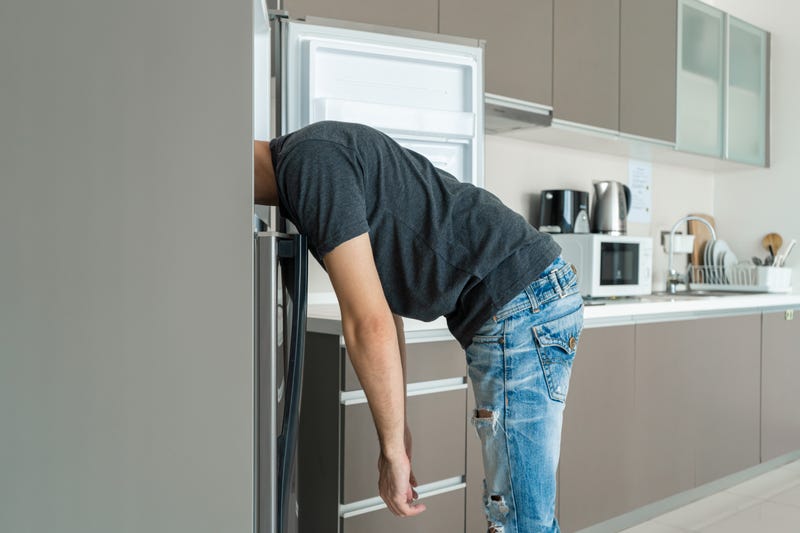 man sticking head in freezer