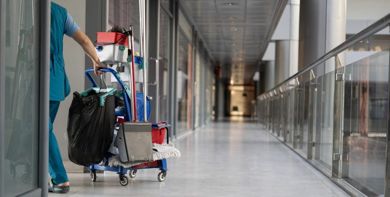 A worker cleans a hospital hallway
