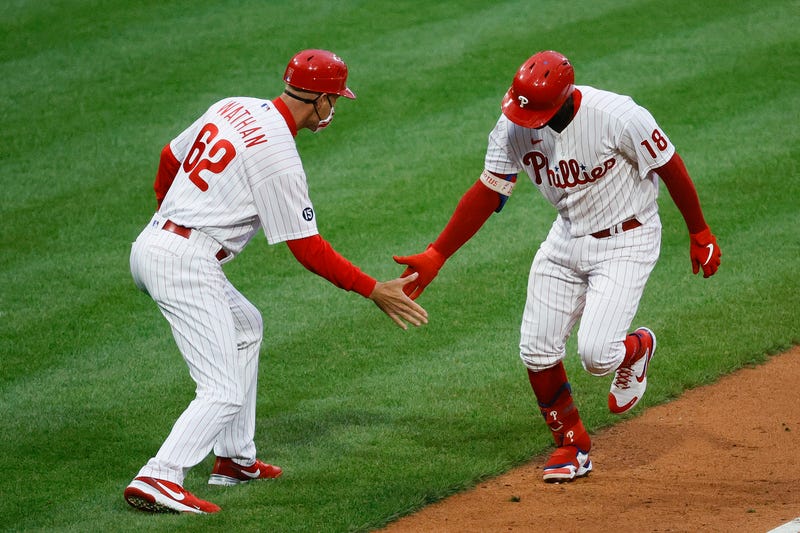 Didi Gregorius #18 (R) and Dusty Wathan #62 of the Philadelphia Phillies celebrate Gregorius's grand slam home run during the first inning against the Milwaukee Brewers at Citizens Bank Park on May 05, 2021 in Philadelphia, Pennsylvania.