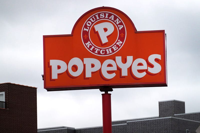 A sign hangs outside of a Popeyes Louisiana Kitchen restaurant