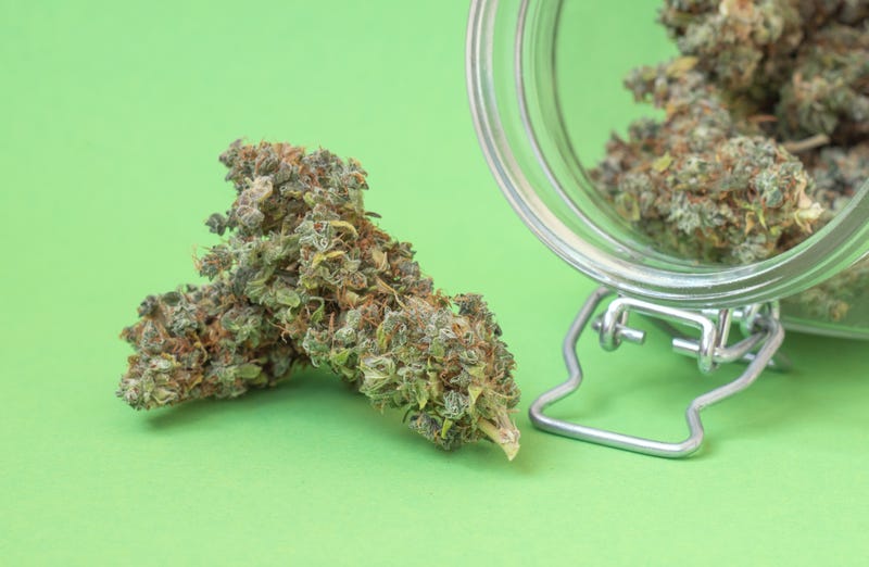 Weed next to a jar full of weed