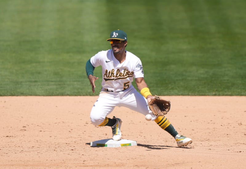 Tony Kemp #5 of the Oakland Athletics can't handle the throw in the dirt for an error from pitcher Deolis Guerra #65 against the Toronto Blue Jays in the six inning at RingCentral Coliseum on May 06, 2021 in Oakland, California.