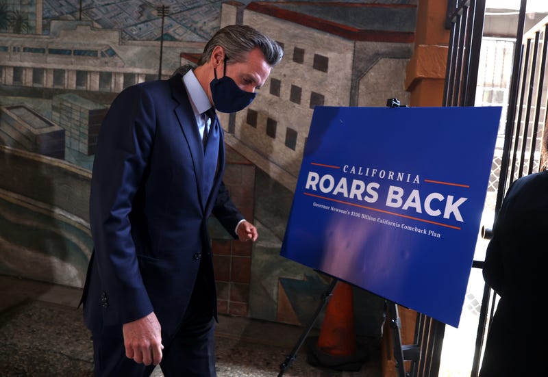 California Gov. Gavin Newsom walks by a sign as he leaves a press conference at The Unity Council on May 10, 2021 in Oakland, California.