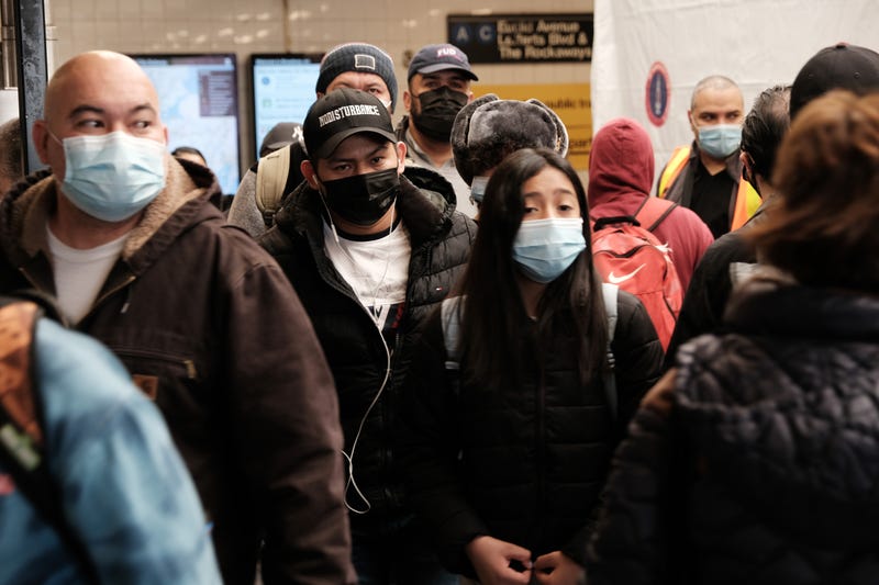 People move through the Broadway Junction subway station in Brooklyn as others wait in line to get a COVID-19 vaccination shot on May 12, 2021 in New York City