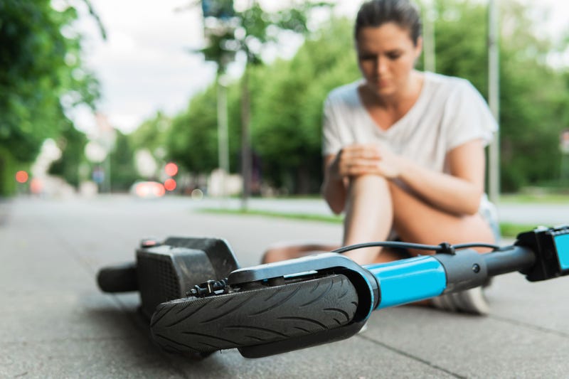 Riding electric scooters in bike lane past traffic jam