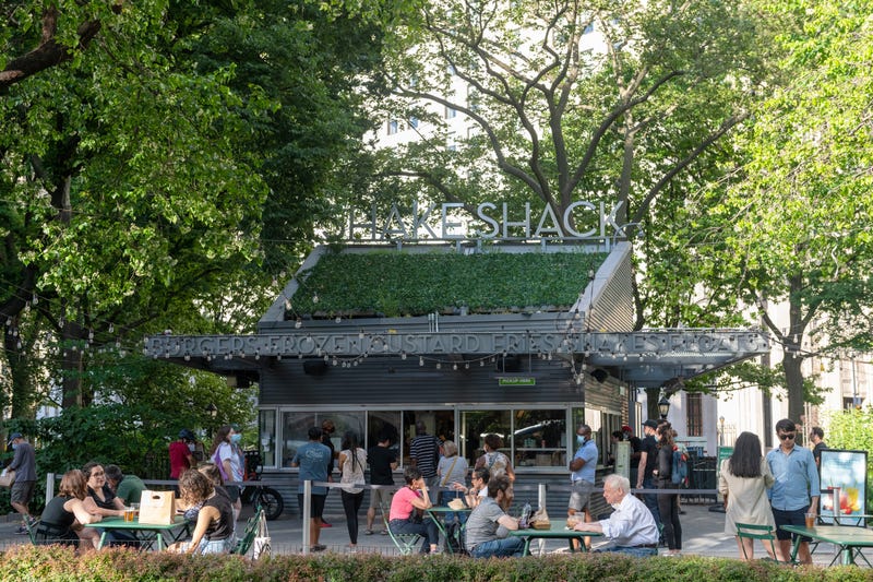 A bicycle delivery person stands near a Shake Shack in Midtown on February 08, 2021 in New York City.
