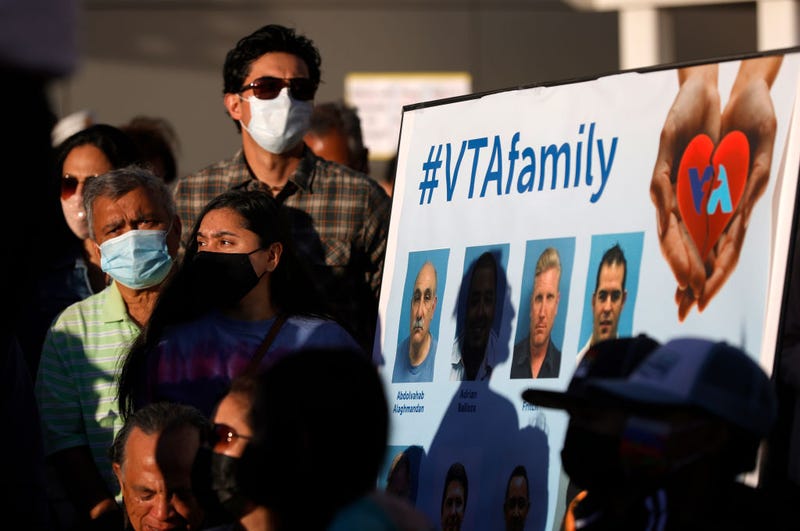 Mourners stand next to a poster with images of the nine Santa Clara Valley Transportation Authority (VTA) light rail yard shooting victims during a vigil at San Jose City Hall on May 27, 2021 in San Jose, California.