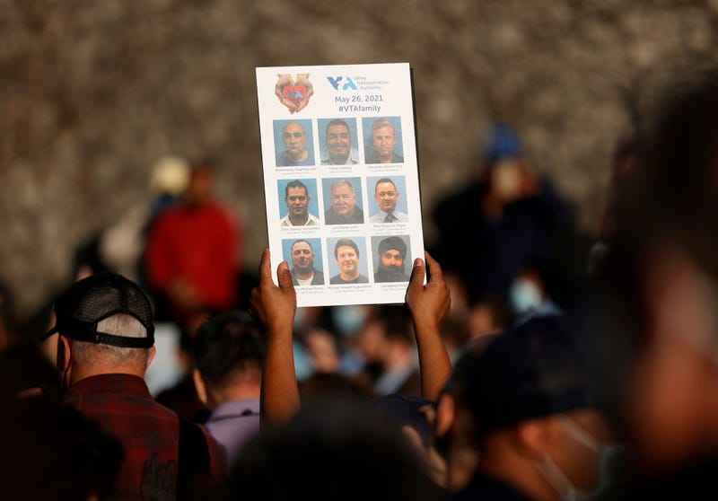 A mourner holds a sign with images of the nine Santa Clara Valley Transportation Authority (VTA) light rail yard shooting victims during a vigil at San Jose City Hall on May 27, 2021 in San Jose, California.