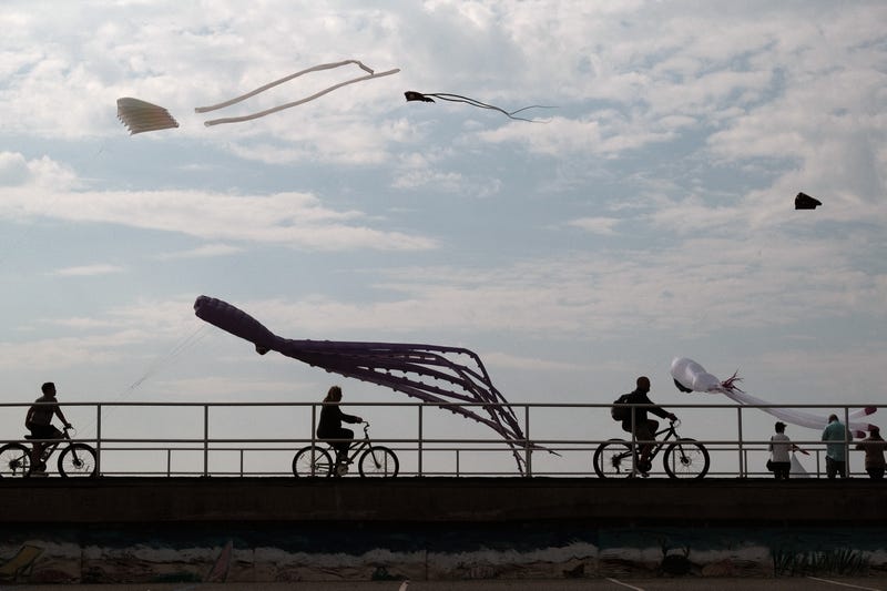 People walk and ride along the boardwalk