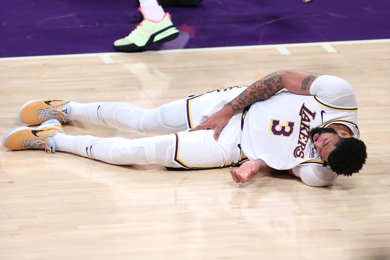 Lakers star Anthony Davis down on the court in pain.