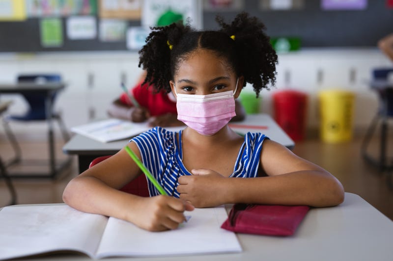 student at desk wearing face mask