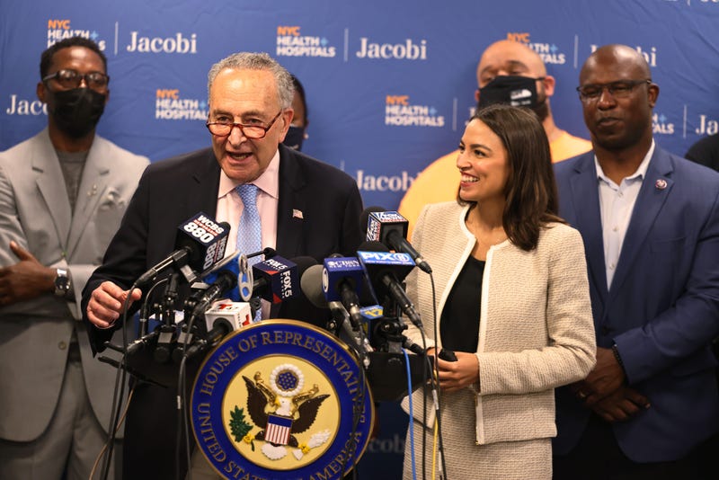 Senate Majority Leader Chuck Schumer (D-NY) answers questions as Rep. Alexandria Ocasio-Cortez (D-NY) smiles during a press conference at Jacobi Hospital in the Morris Park neighborhood on June 03, 2021 in the Bronx