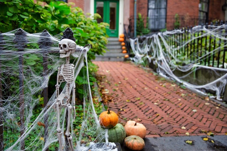 Halloween decorations on a home; Skeleton and spider web on a fence
