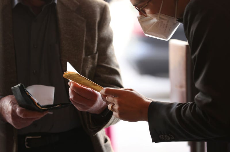 An employee of Deutsche Oper Berlin checks the vaccination certificate of a guest arriving for the premiere performance of "Das Rheingold" during the coronavirus pandemic on June 12, 2021 in Berlin, Germany.