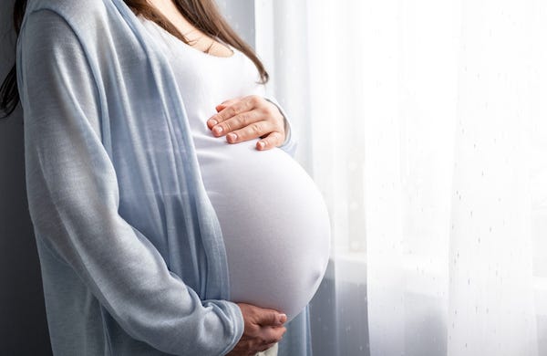 Pregnant woman standing by window